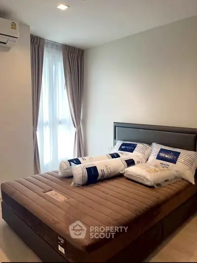 Cozy bedroom with plush bed and natural light, perfect for relaxation.