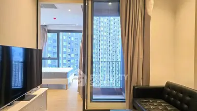 Modern apartment with sleek living room and bedroom view, featuring large windows and cityscape.