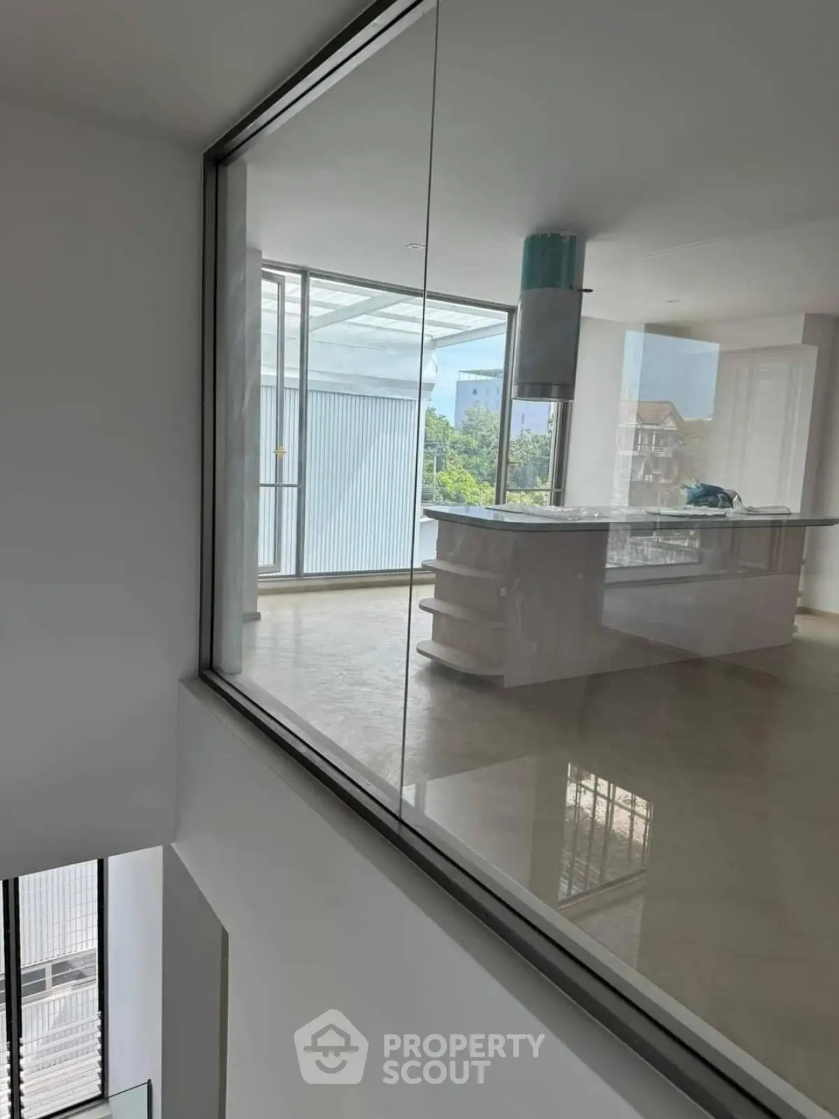 Spacious modern kitchen with island and large windows offering natural light and scenic views.