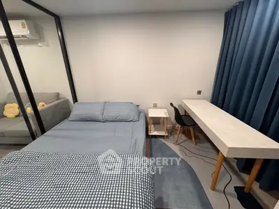 Modern bedroom with glass partition and study area, featuring cozy bedding and stylish furniture.