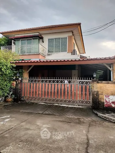 Charming two-story house with gated entrance and spacious driveway, perfect for family living.