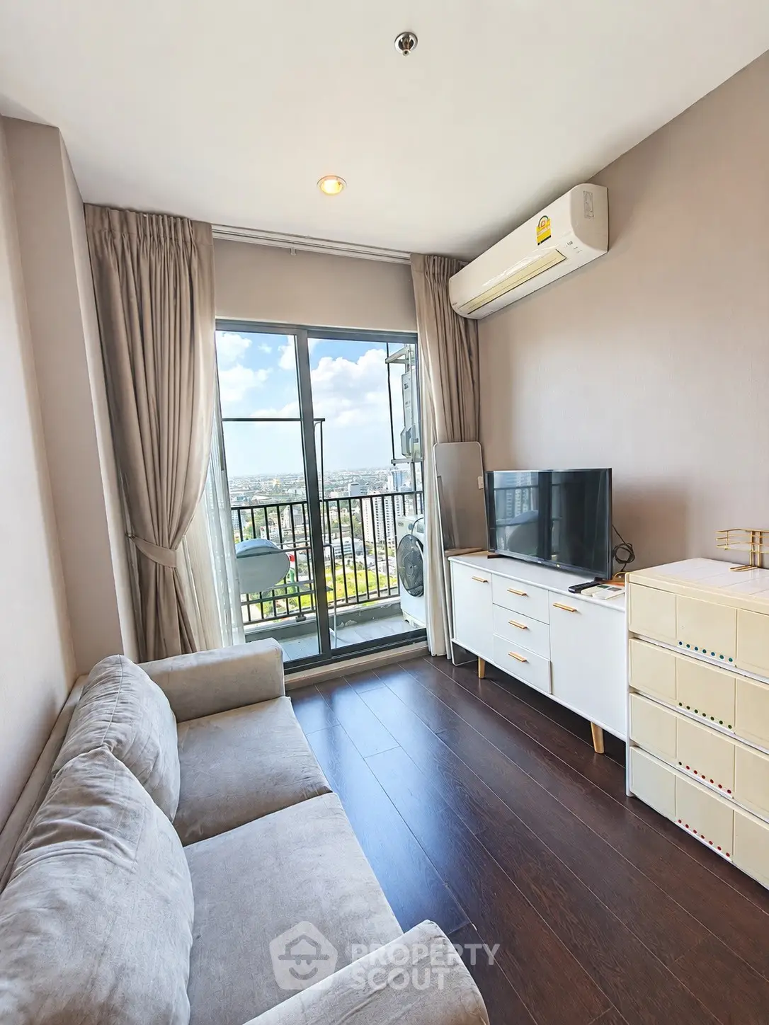 Modern living room with balcony view, featuring sleek furniture and natural light.