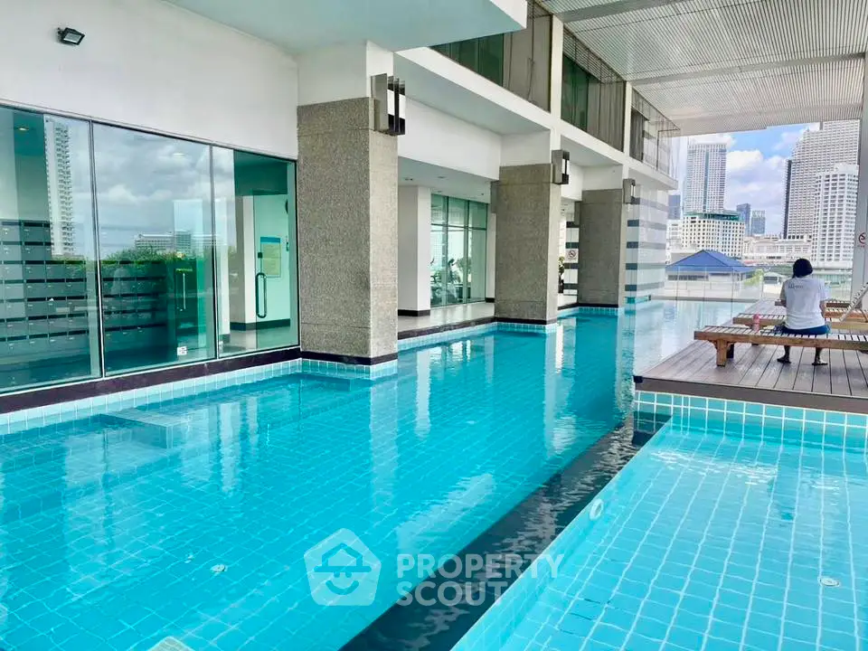 Luxurious rooftop pool with city skyline view in modern high-rise building.