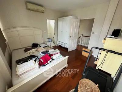 Spacious bedroom with wooden flooring and ample storage in a cozy home.