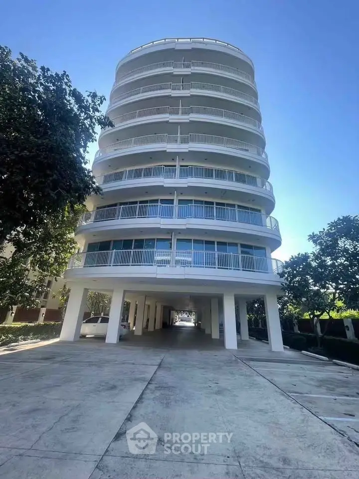 Stunning modern building with unique circular balconies and spacious parking area, perfect for urban living.