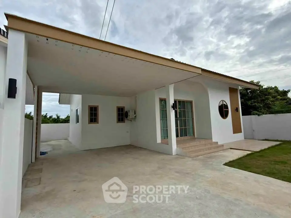 Charming single-story home with covered carport and lush green lawn, perfect for family living.