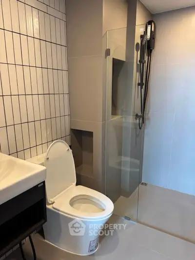 Modern bathroom with sleek shower and contemporary fixtures in stylish real estate property.