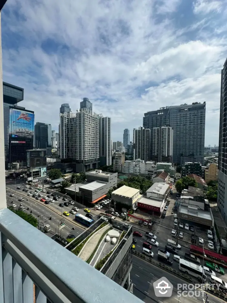 Stunning cityscape view from high-rise balcony overlooking bustling urban streets.