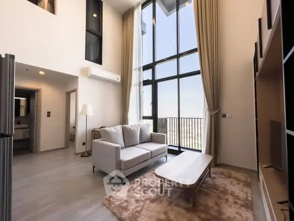 Spacious modern living room with high ceilings and large windows offering a stunning view.