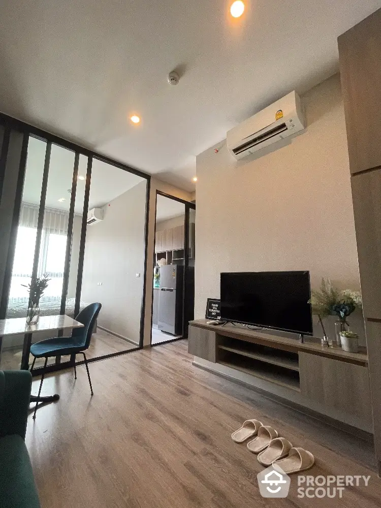 Modern living room with sleek design, featuring a TV unit, air conditioning, and stylish decor.