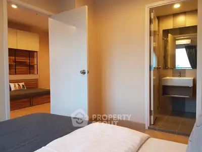 Modern bedroom with ensuite bathroom and cozy seating area, ideal for relaxation.
