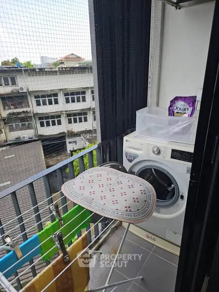 Compact balcony with washing machine and laundry setup in urban apartment