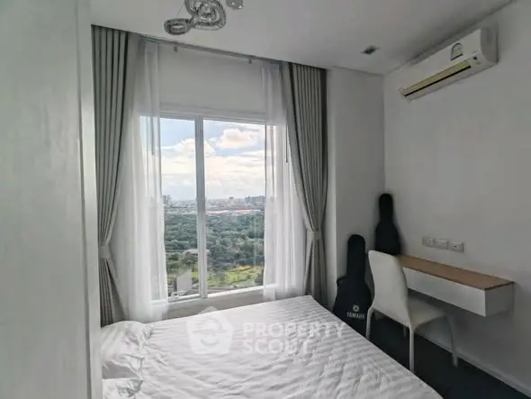 Cozy bedroom with scenic view and modern furnishings in high-rise apartment.