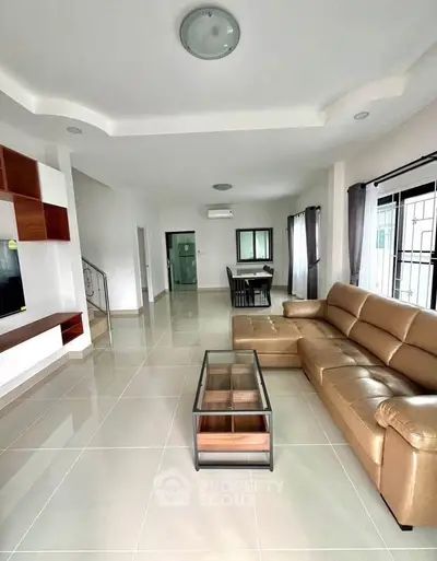Spacious modern living room with leather sofa and sleek glass coffee table