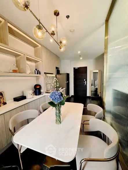 Modern kitchen with elegant dining area and stylish lighting in a contemporary apartment.