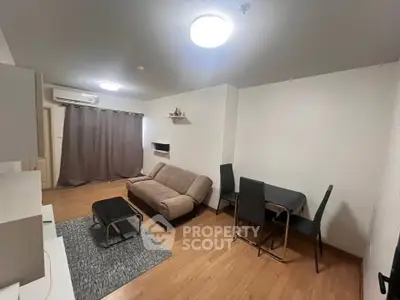 Modern living room with cozy sofa and dining area, featuring wooden flooring and ambient lighting.