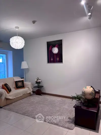 Charming living room with cozy decor and modern lighting, perfect for relaxation.