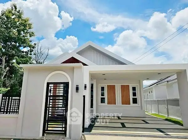 Modern single-story house with sleek design and spacious driveway under a bright blue sky.