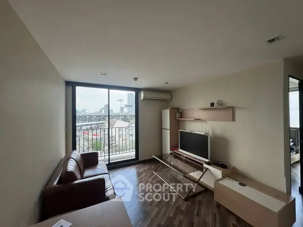 Modern living room with city view, featuring sleek furniture and large windows for natural light.