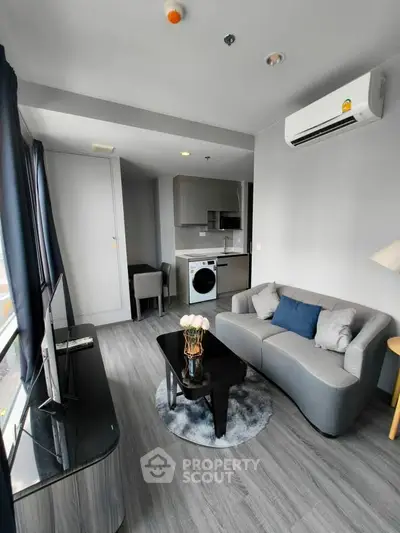 Modern living room with sleek furniture and integrated kitchen appliances in a stylish apartment.