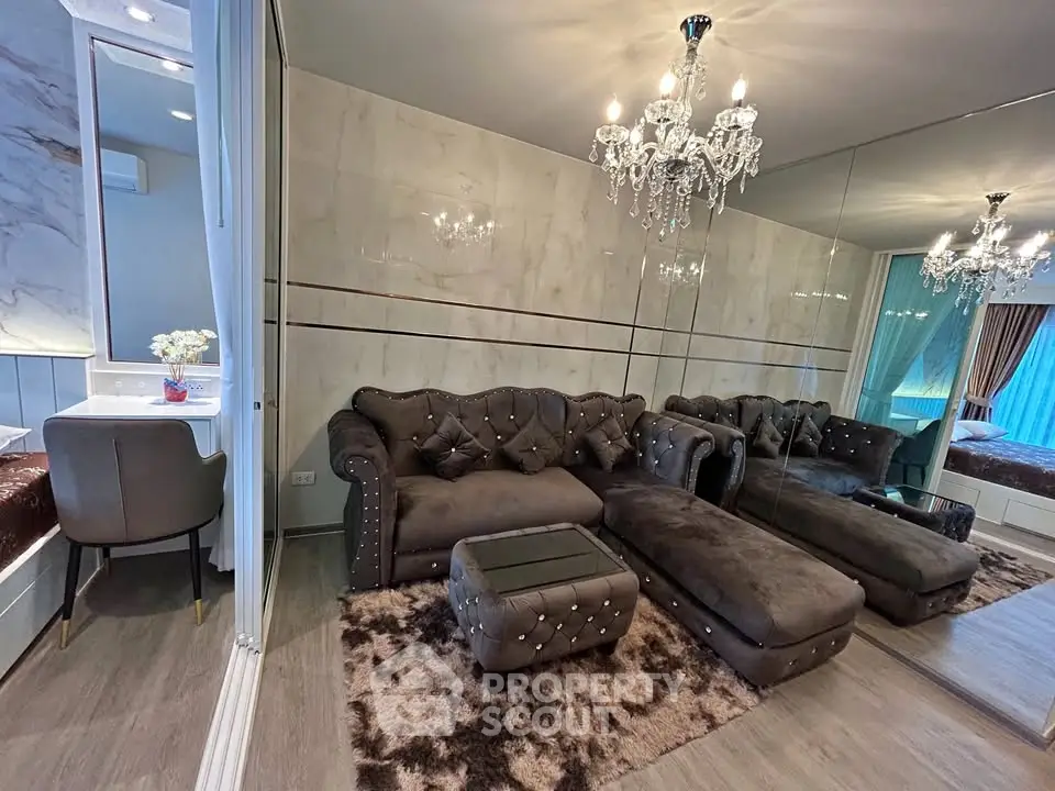 Luxurious living room with plush seating and elegant chandelier in modern apartment.