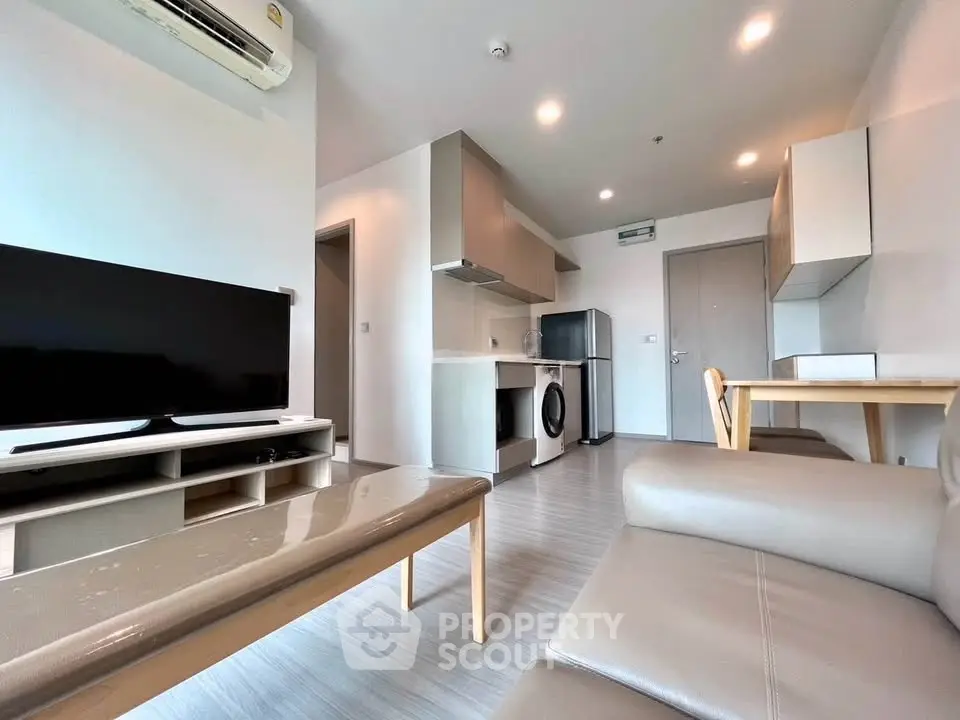 Modern living room with sleek furniture and integrated kitchen appliances in a stylish apartment.