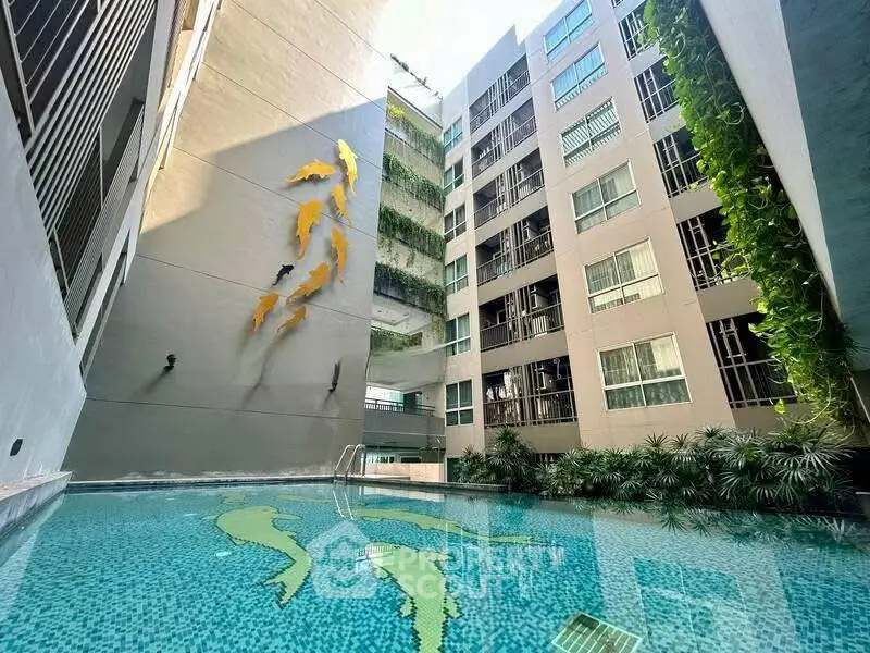 Modern apartment building with artistic pool and lush greenery