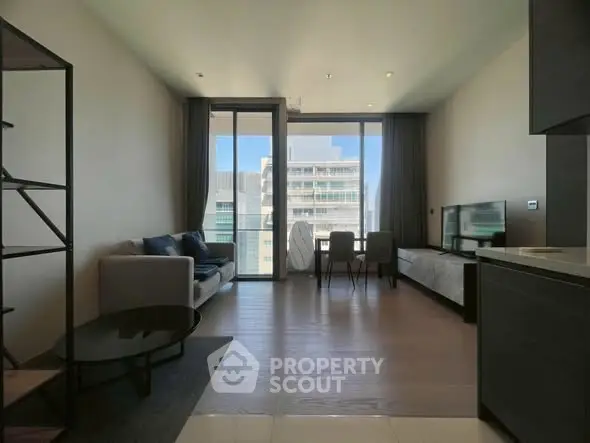 Modern living room with large windows and city view, featuring sleek furniture and open layout.