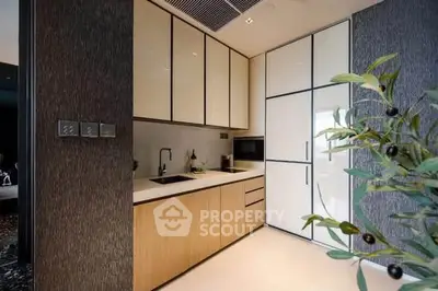 Modern kitchen with sleek cabinetry and integrated appliances in luxury apartment.
