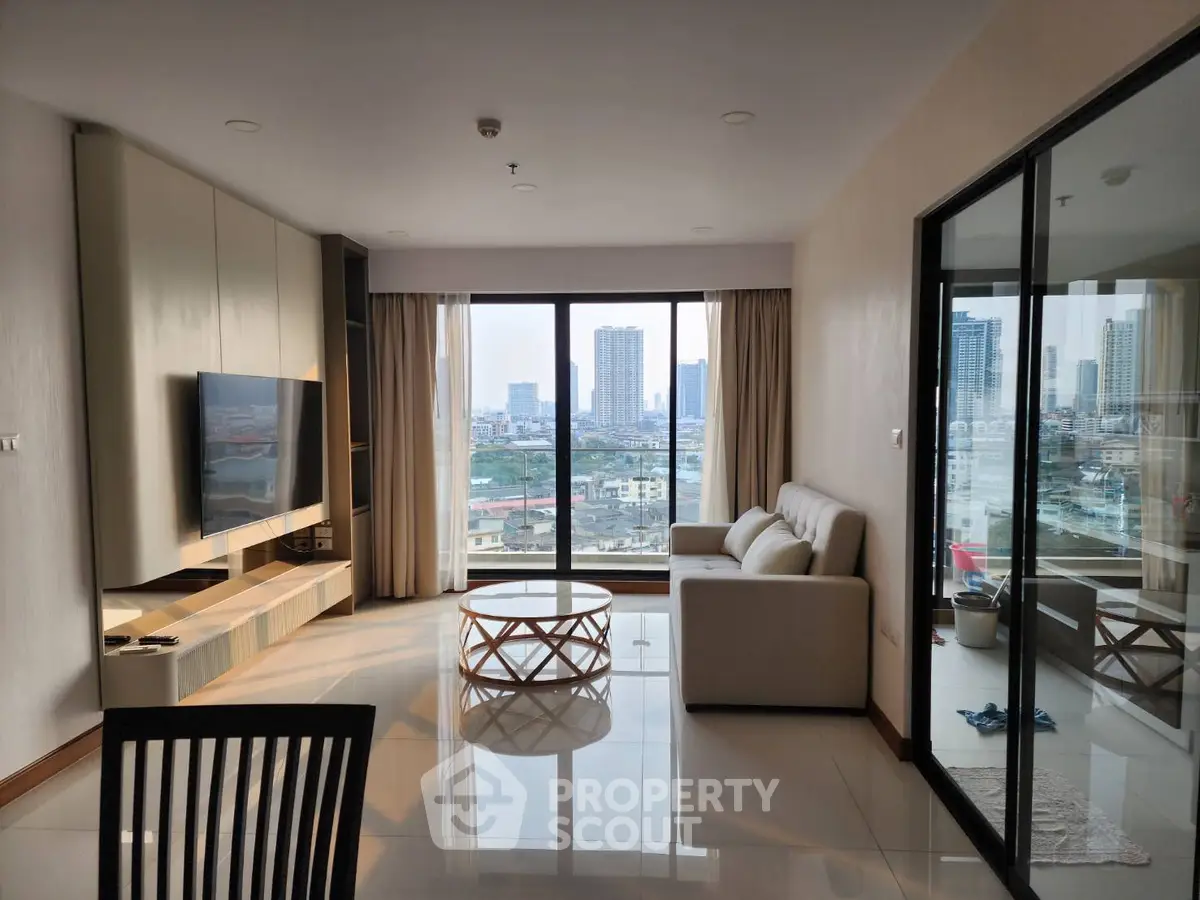 Modern living room with city view, sleek furniture, and large windows in a high-rise apartment.