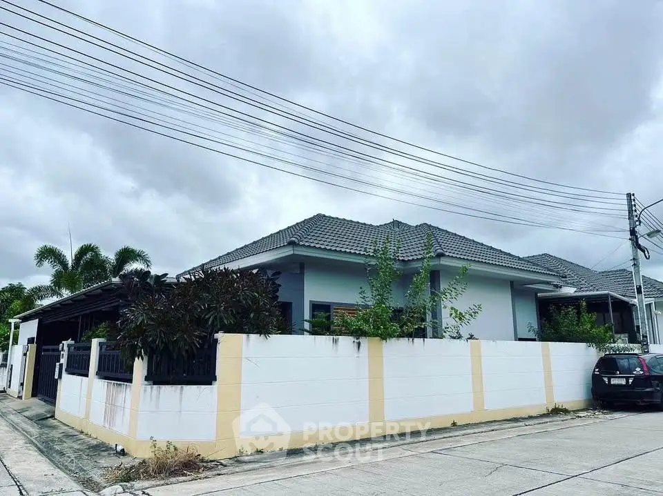 Charming single-story home with a fenced yard and lush greenery, perfect for family living in a serene neighborhood.