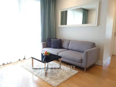 Stylish living room with modern sofa, elegant mirror, and natural light
