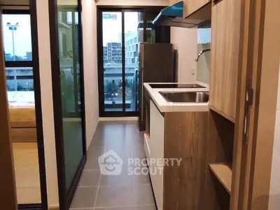 Modern kitchen with sleek design and city view, featuring stainless steel appliances and ample storage space.