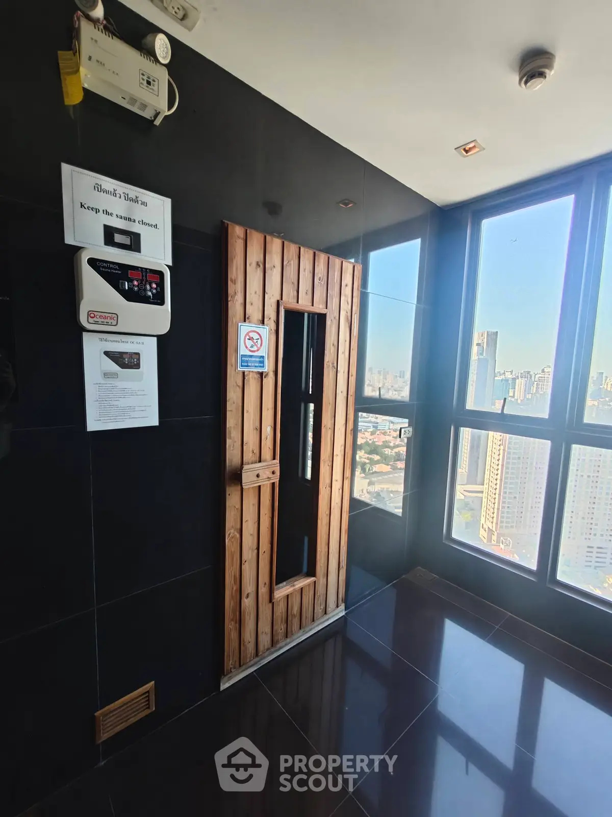 Modern building elevator lobby with city view and wooden sauna door