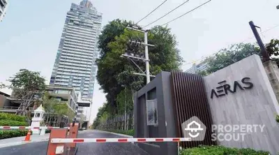 Modern high-rise building with lush greenery and secure entrance gate