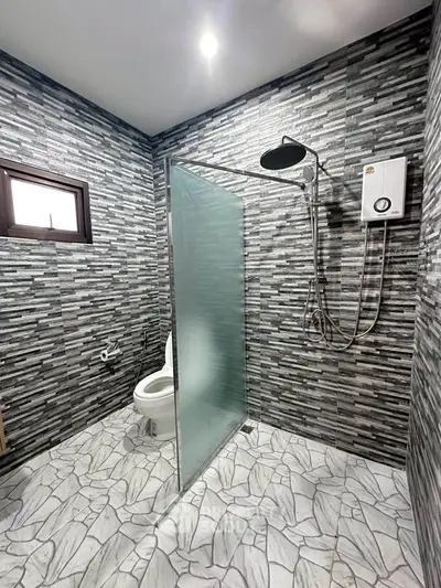 Modern bathroom with sleek tile design and glass shower partition