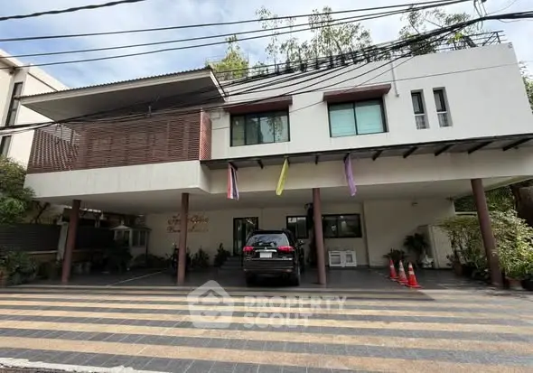 Modern building exterior with parking area and sleek design elements.