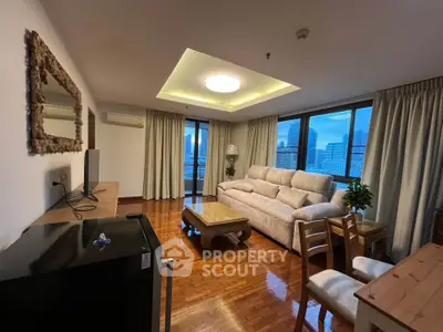 Spacious living room with city view, elegant furnishings, and natural light.