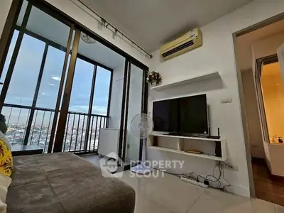 Modern living room with city view and balcony access, featuring sleek design and natural light.