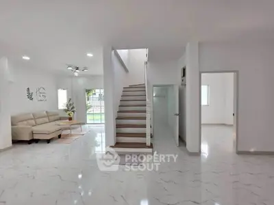 Spacious modern living room with elegant staircase and cozy seating area