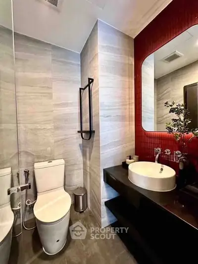 Modern bathroom with sleek fixtures and stylish red accent wall