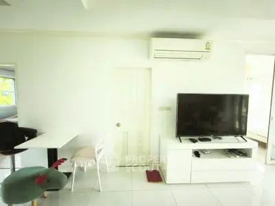 Modern living room with sleek white furniture and air conditioning unit, perfect for cozy relaxation.