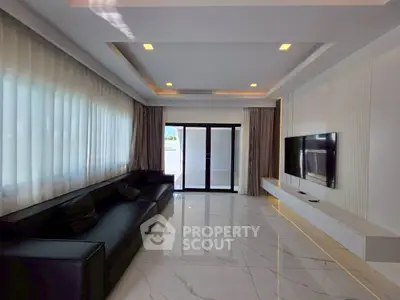 Luxurious modern living room with sleek black sofa and wall-mounted TV