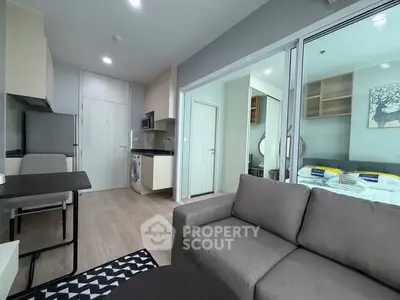 Modern open-plan living room with kitchen and bedroom in a stylish apartment.