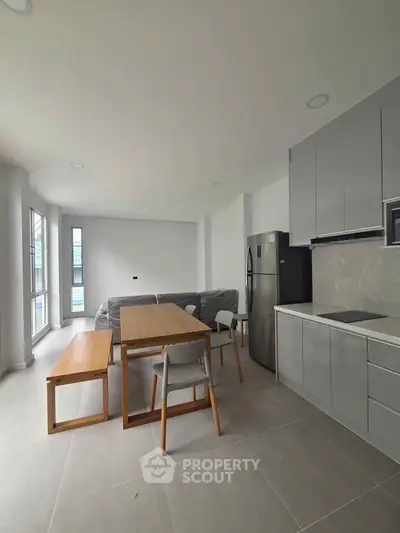 Modern kitchen with sleek cabinetry and dining area in open layout apartment