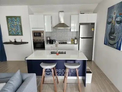 Modern kitchen with island, stainless steel appliances, and stylish decor in a contemporary apartment.