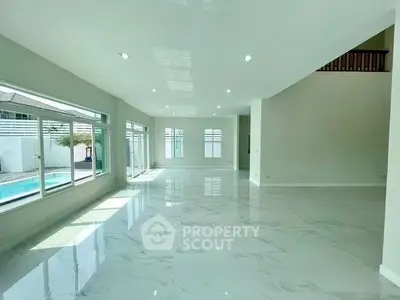 Spacious modern living room with large windows and pool view