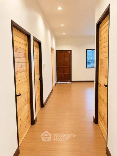 Spacious hallway with wooden doors and elegant flooring in modern home