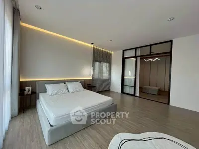 Spacious modern bedroom with elegant lighting and mirrored closet doors