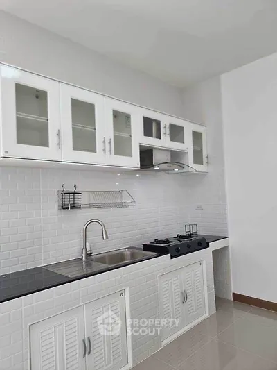 Modern kitchen with sleek white cabinets and gas stove